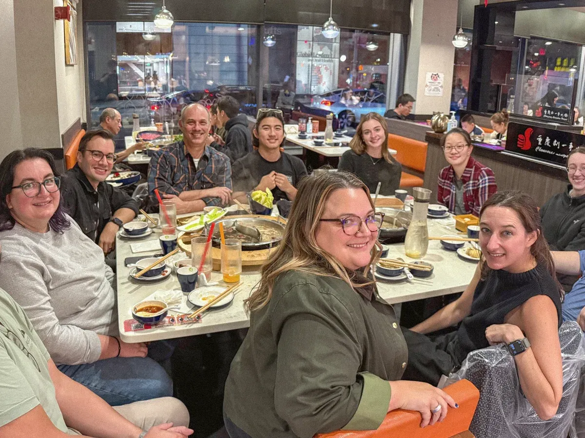 The design team around a long table at a hot pot restaurant